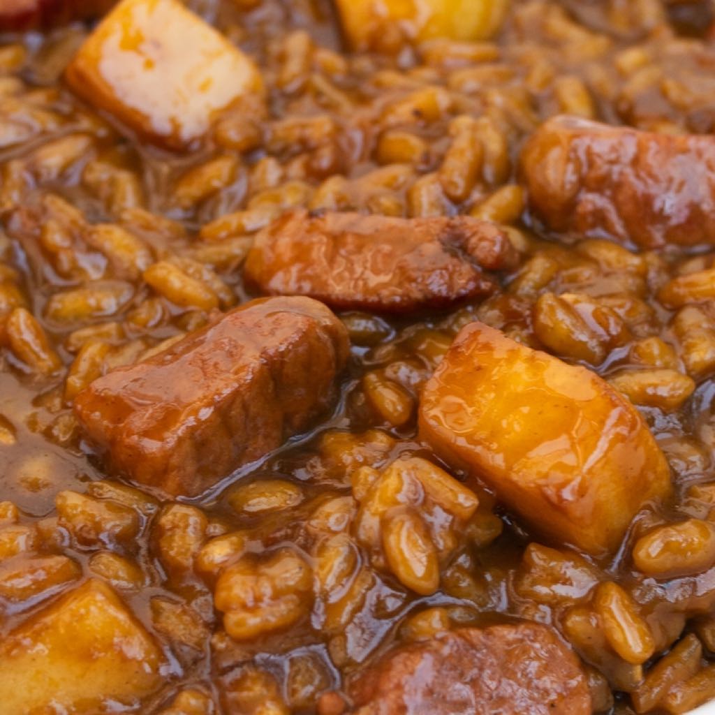 An image of Arroz meloso con secreto de cerdo y manzana